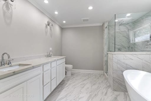Spacious marble bathroom with double vanity, freestanding tub, and glass shower